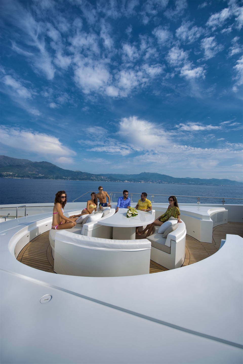 Guests in the bow lounge of M/Y My Dream under a blue sky