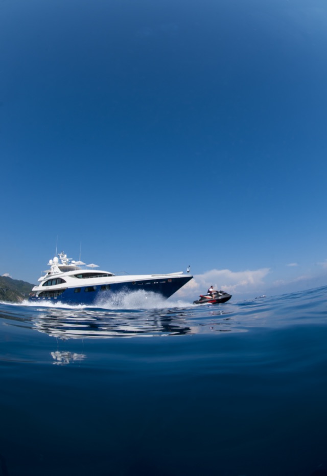 Half-water shot of M/Y My Dream with a jet ski, the sea surface splitting the frame